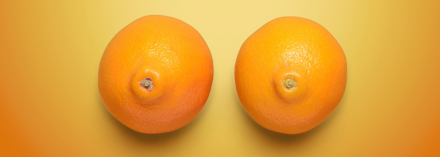 Zwei nebeneinander liegende Orangen, die von oben fotografiert an weibliche Brüste erinnern.